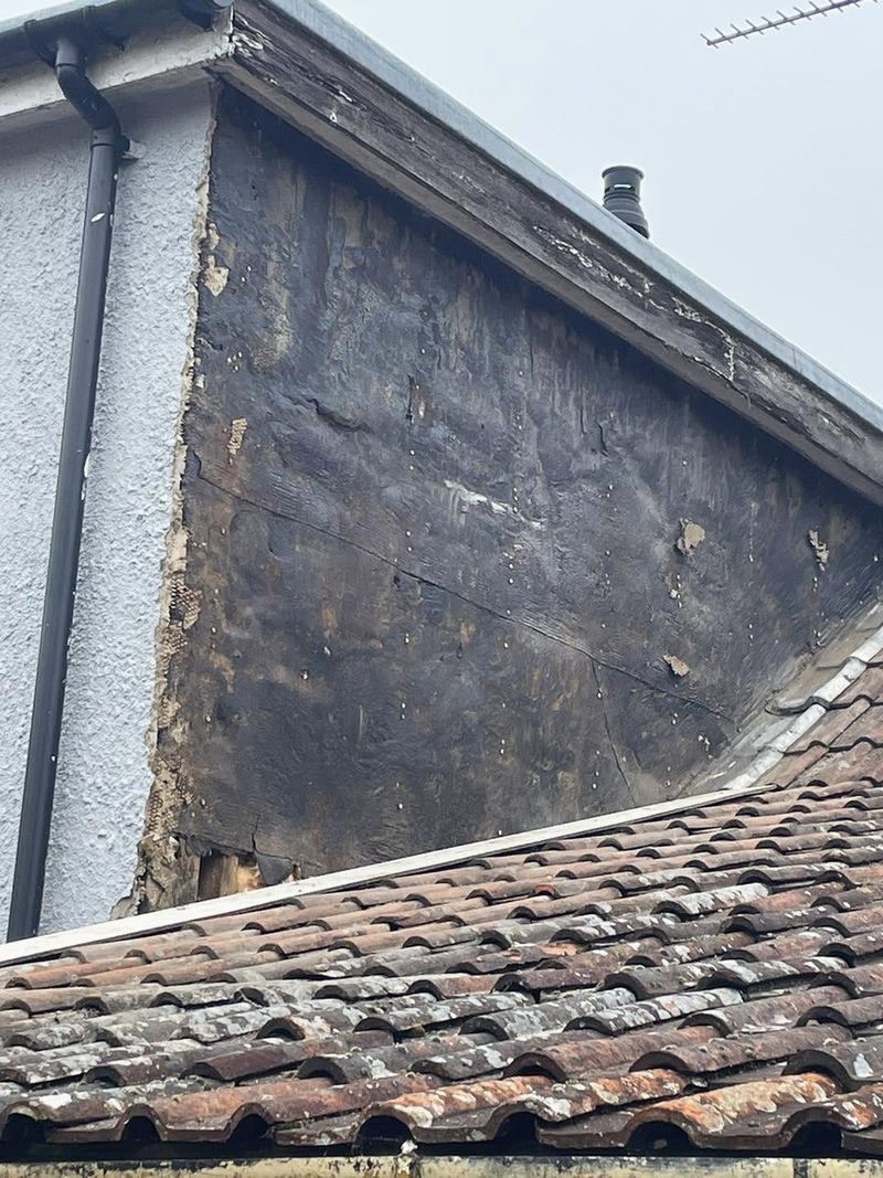 A dormer cheek before rendering, old covering showing